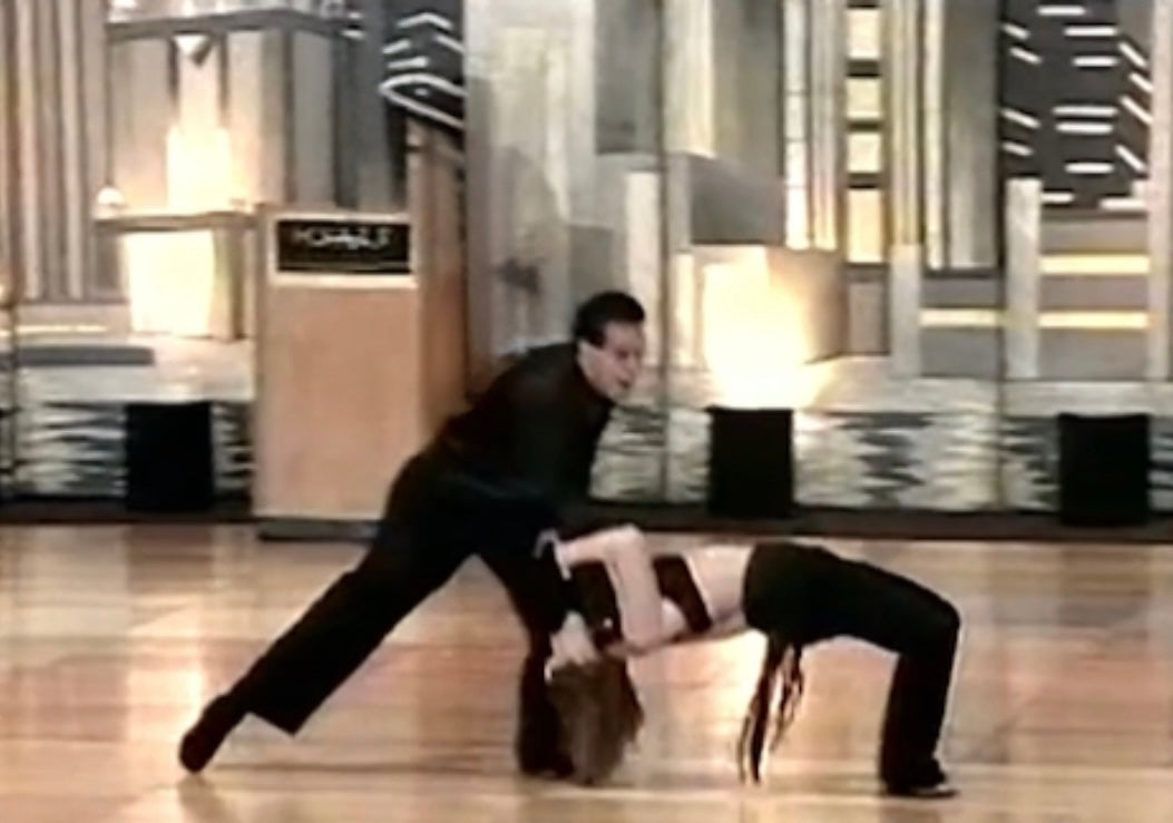 A dance couple performing west coast swing dance at a national competition